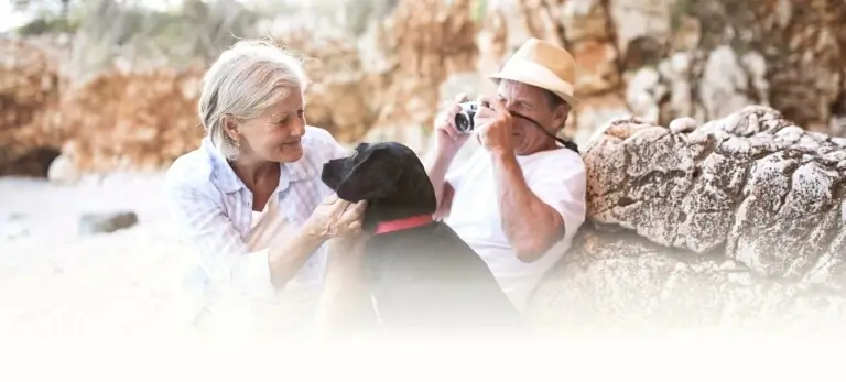 Senior couple relaxing with dog on the beach